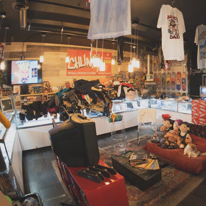 The Chunxx lounge corner: glass display counter, red couch, plush toys and a CRT TV under the CHUNXX sign