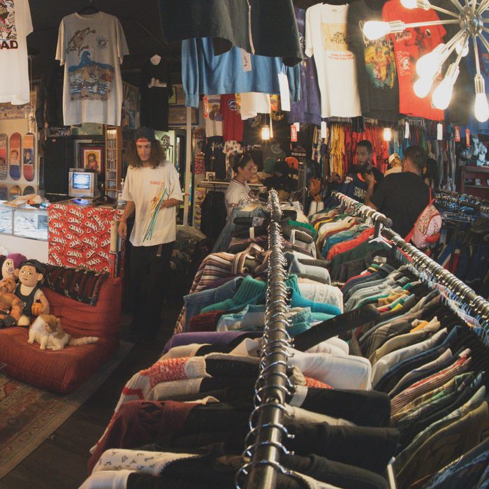 Long rack of vintage jackets and sweaters running through the shop